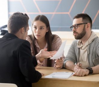 Angry millennial couple complaining having claims about bad contract terms disputing at meeting with lawyer, deceived dissatisfied customers demanding compensation, legal fight and fraud concept